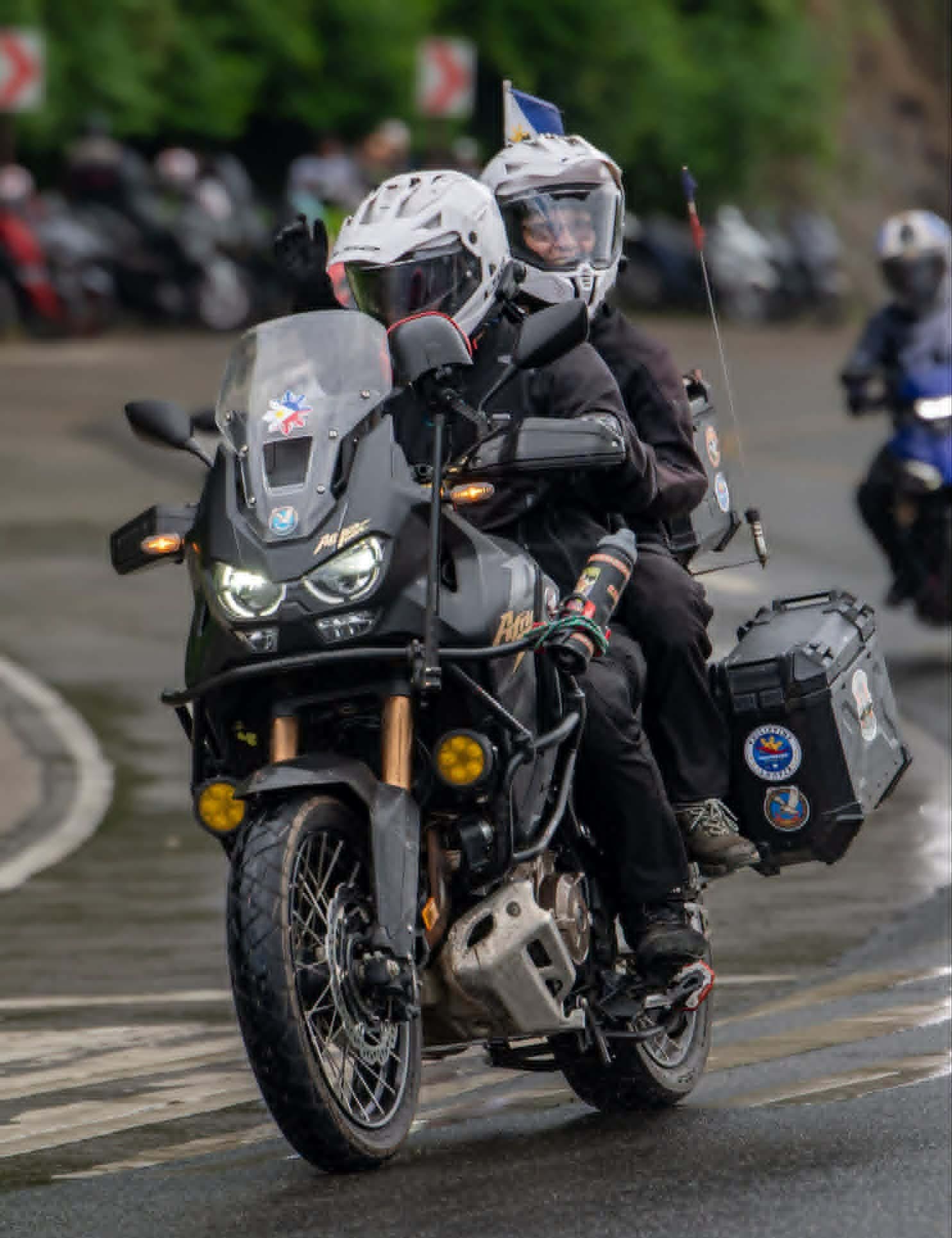 Two riders carrying the Philippine flag